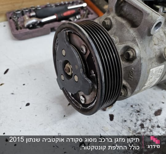 מדחס רכב עם גלגלת ותיבת כלים ברקע